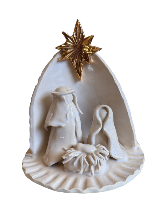 White nativity scene figurine with gold star on a white background